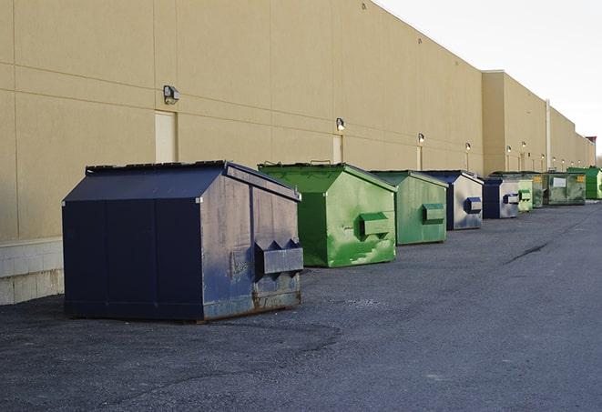 tilted front-load dumpsters being emptied by waste management workers in Batavia IL